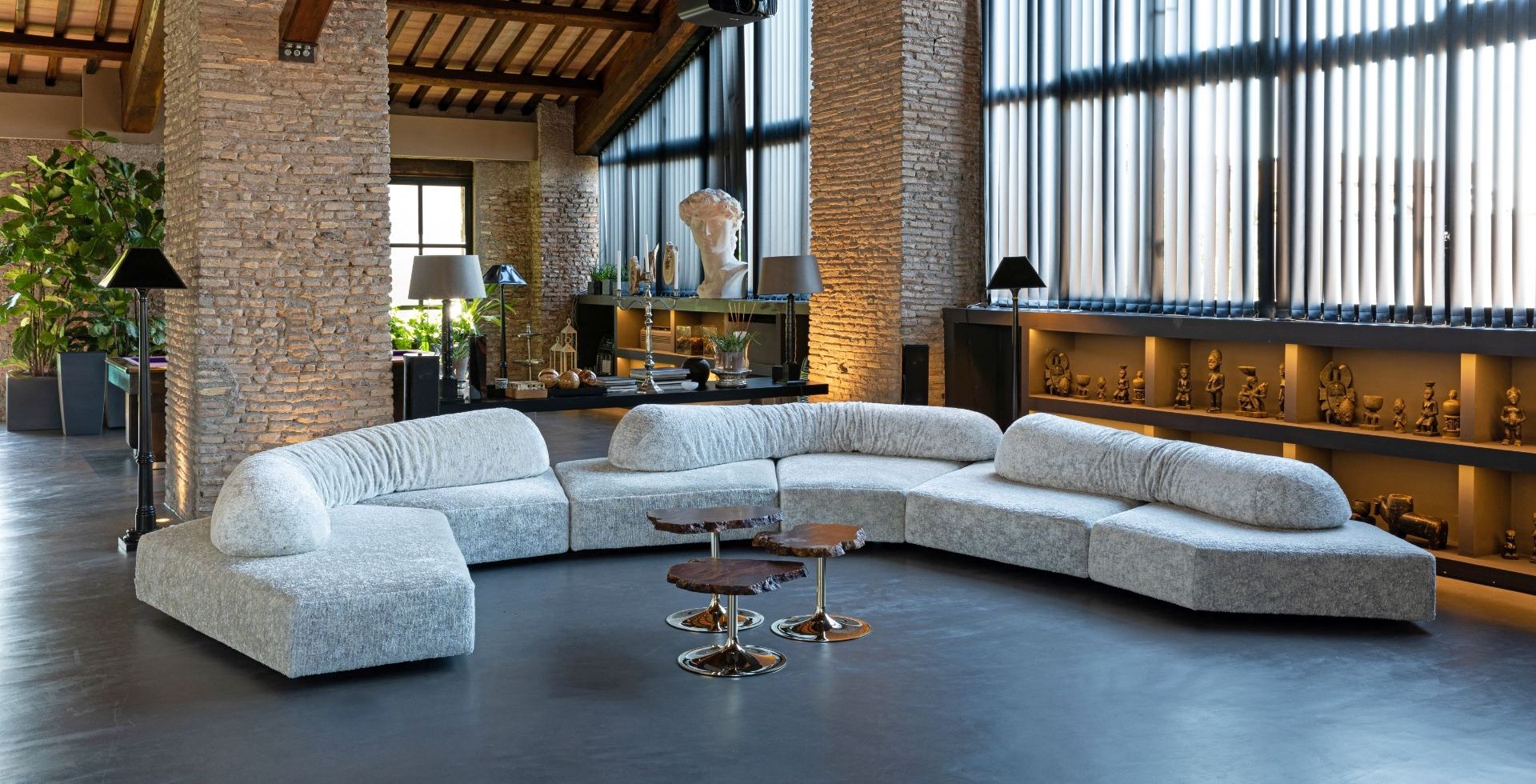 Edra On the Rocks sectional sofa in a warm architectural interior with brick columns and tall windows